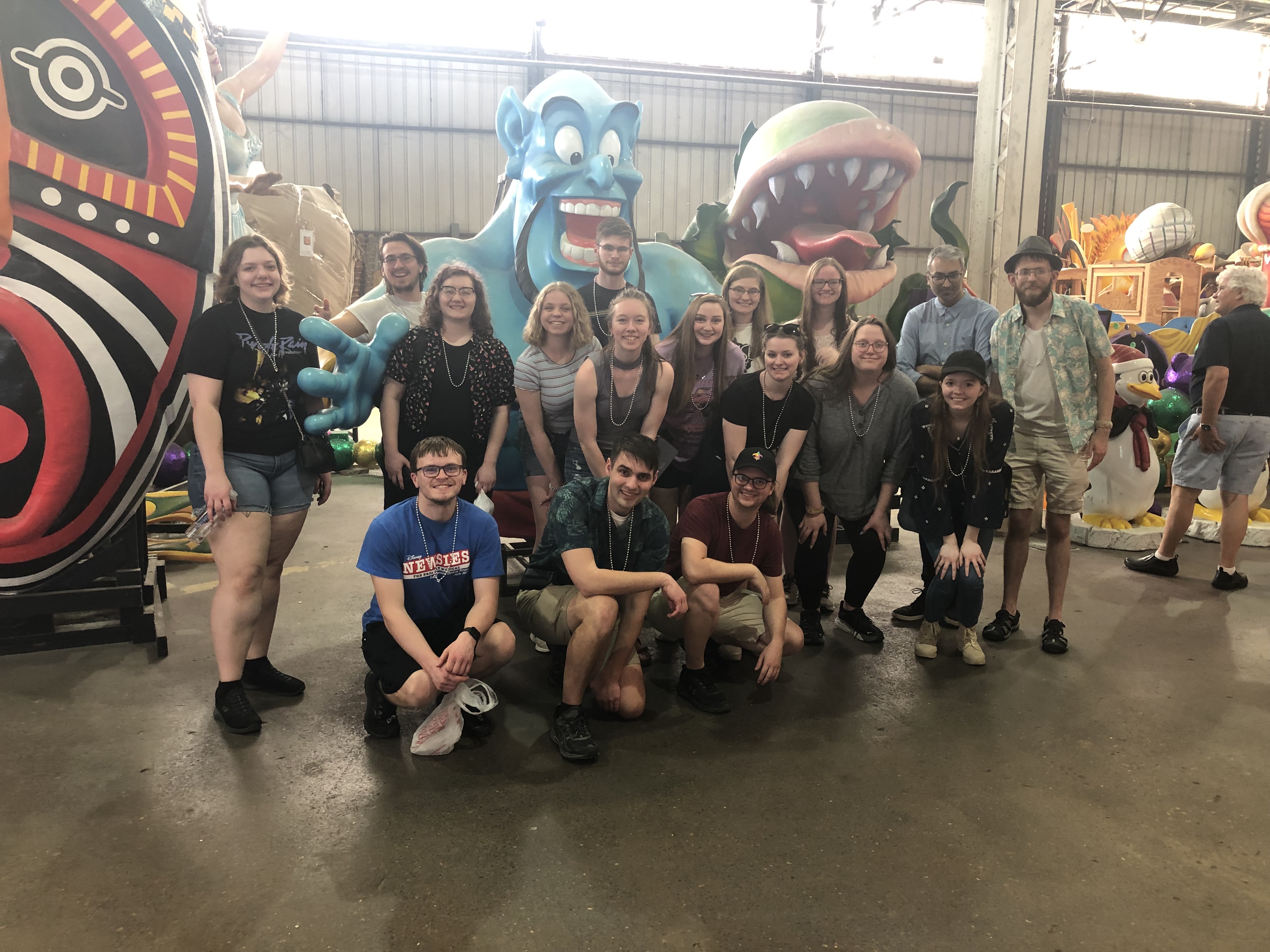 Members of the jazz band at Mardi Gras World in New Orleans, posing in front of a figure of the genie from Disney's Aladdin.